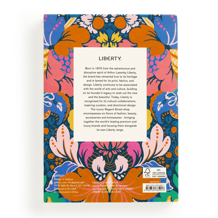 The Liberty Glastonbury Premium A5 Notebook by Liberty London has a back cover with a vibrant blue, orange, pink, and yellow floral and leaf design and a centered white box featuring black text about the notebook.