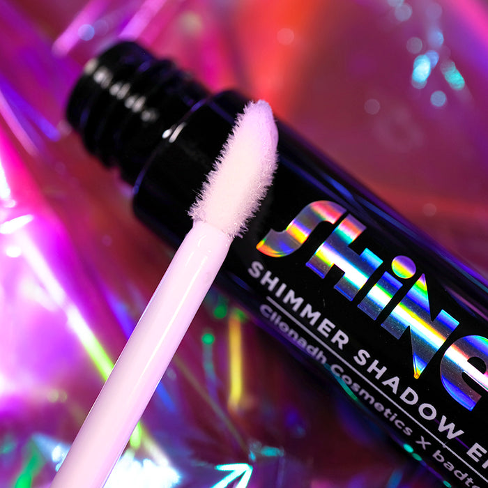 Close-up of the Shine-On Shimmer Shadow Enhancer bottle and application brush.