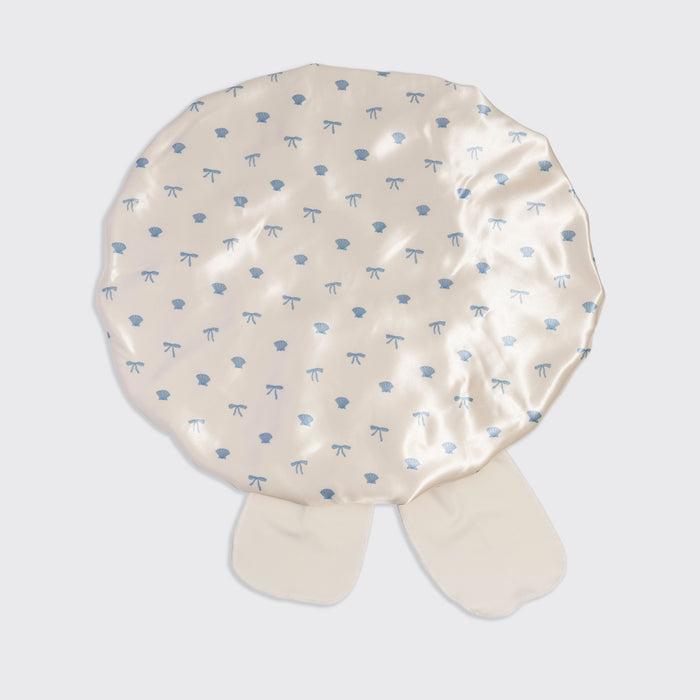 KITSCH Pearlized Cream & Coastal Blue Print Oversized Satin Bonnet — standalone overhead flat lay showing full coastal blue seashells & bows print on pearlized cream satin — Adjustable, double-layered satin — For preserving your hair overnight