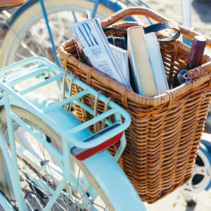 A Bluejay e-bike in Mint Green with a Pannier Nantucket basket attached to its rear rack.