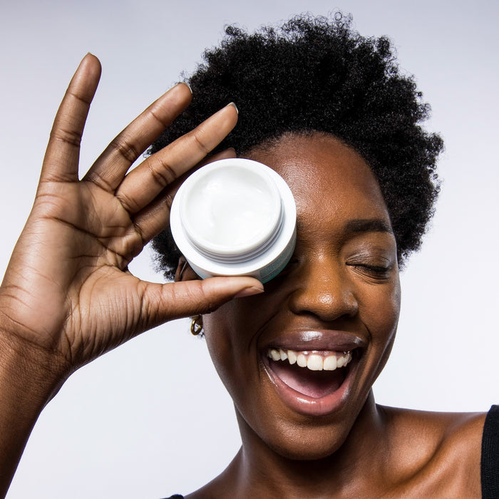 Woman holding an open jar of USRx Hydrabalance Moisturizer