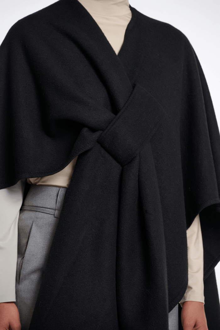 Black wrap over a neutral outfit on a white background