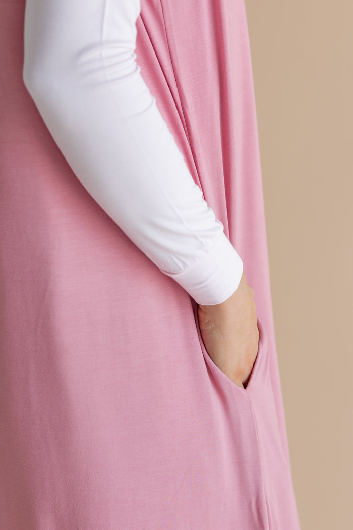 Pink sleep sack with functional pocket against a cream background