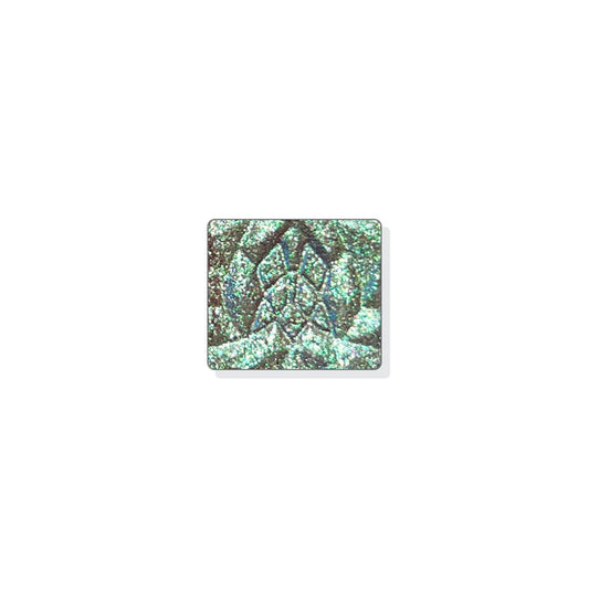 A single multichrome eyeshadow in colour Amalgam on a white background. A pale brown base and particles that shift minty green-silvery blue-lavender with hints of red and silver sparkle.