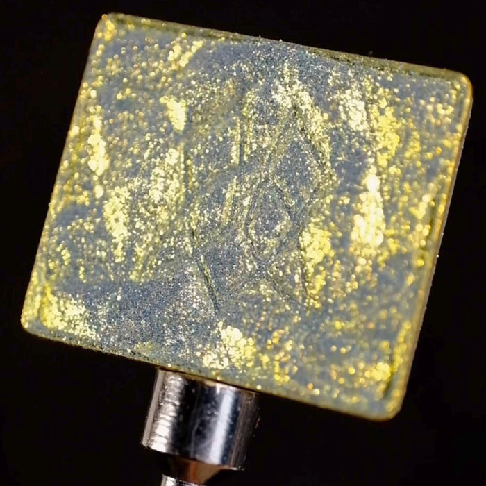 Close-up of Aureate eyeshadow in a single pan, on a black background.
