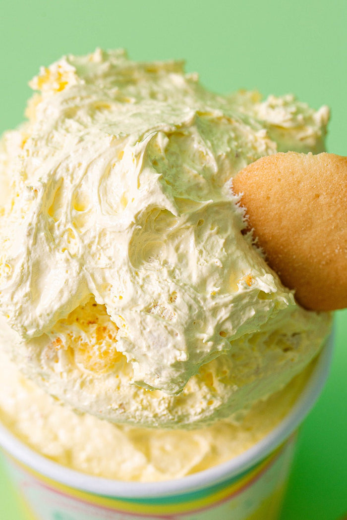 A zoomed in photo of the top of the banana pudding marshmallow fluff with the nilla wafer sticking out of it. This photo shows the thick and creamy detail of the XO Marshmallow ooey marshmallow goodness to demonstrate it's texture.