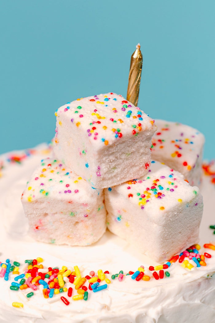 A stack of funfetti marshmallows on top of a birthday cake - featuring them as a best selling marshmallow flavor