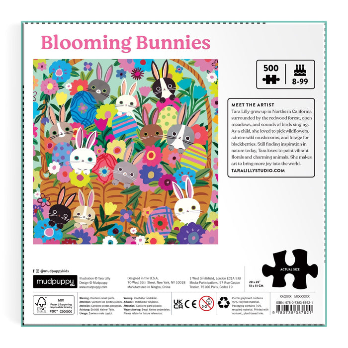 The Tara Lilly Blooming Bunnies 500 Piece Foil Family Puzzle features six bunnies in patterned clothes, surrounded by bright flowers and greenery on a pink background—an enchanting puzzle perfect for ages 8–99.