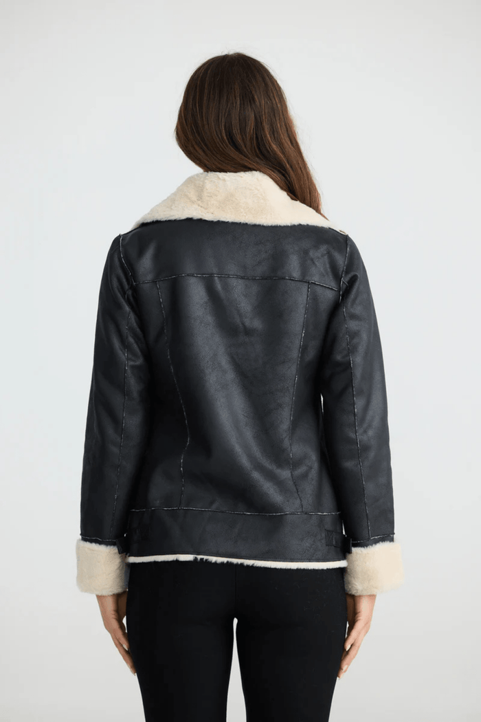 Woman wearing a black coat with white fur trim on a white background. Brave + True BT25161 Haywood Jacket – Black. Shop now at Dotique