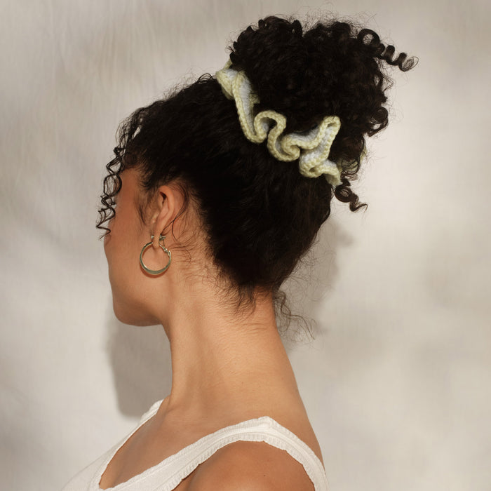Model with curly hair in updo secured with Kitsch Butter Yellow Crochet Scrunchie – coastal hair style