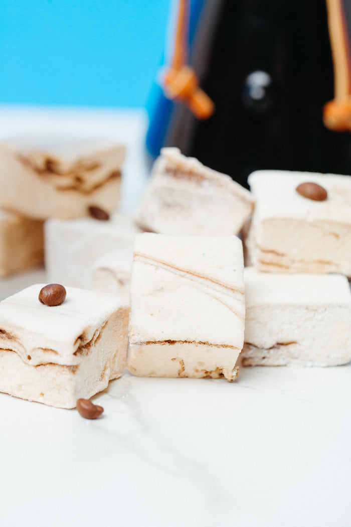 A close up of a pile of caffeinated marshmallows with the coffee carafe in the background