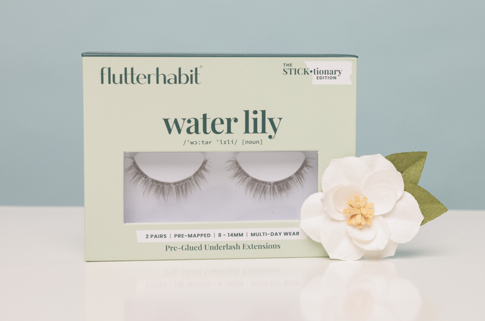 Box of flutterhabit water lily false eyelashes with a white flower on a light gray background