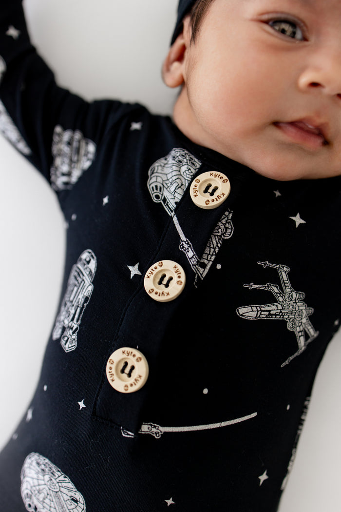 Close up of the Kyte logo buttons on the Knotted Gown with Hat Set in STAR WARS™