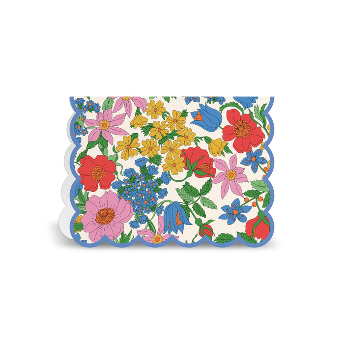 The Liberty Premium Notecard Set by Liberty London features scalloped edges, a blue border, and a vibrant floral design with red, pink, yellow, and blue flowers plus green leaves on a white background.