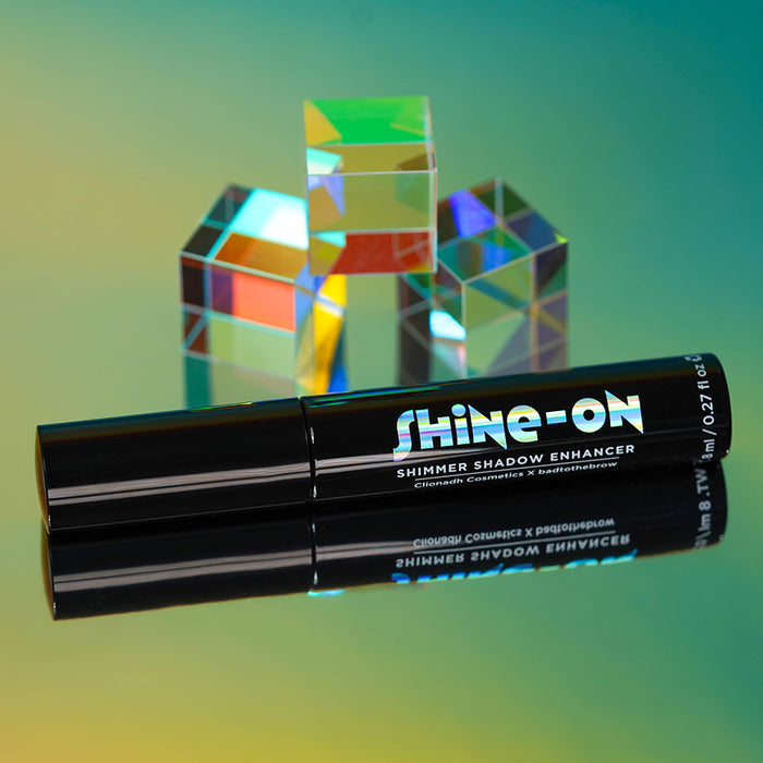 Close-up of the Light Scatters Shine-On Shimmer Enhancer with prisms behind it.
