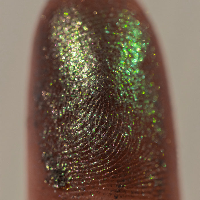 Close-up finger swatch of the eyeshadow Masonry on deep skin tone.