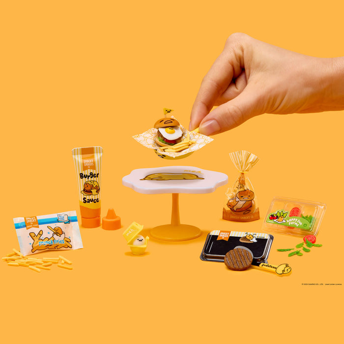 Miniature food items and a hand interacting with them on an orange background