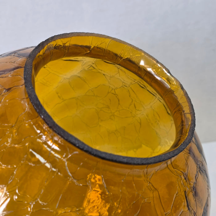 Vintage amber glass crinkle lamp globe casting a warm, patterned glow.