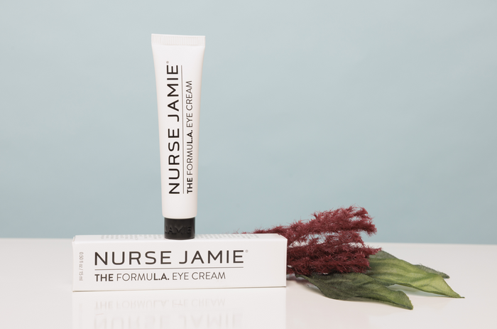Nurse Jamie eye cream tube and packaging on a light surface with a minimal background