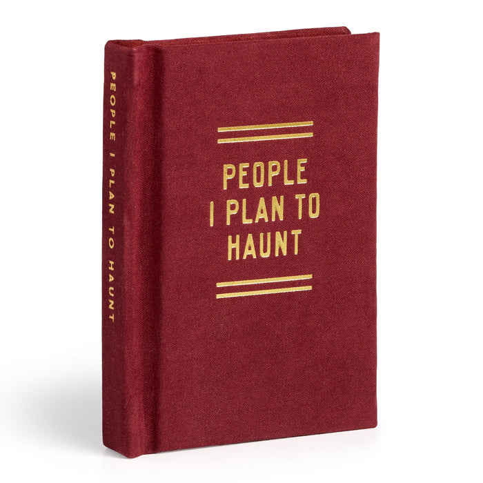 A red hardcover People I Plan To Haunt Tiny Diary by Brass Monkey stands upright, featuring gold capital lettering on the cover and spine—a perfect spooky journal for fans of ghostly stationery.