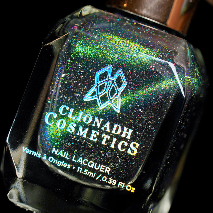 Angled, close-up of Planetary Attraction Nail Lacquer bottle on a black background.