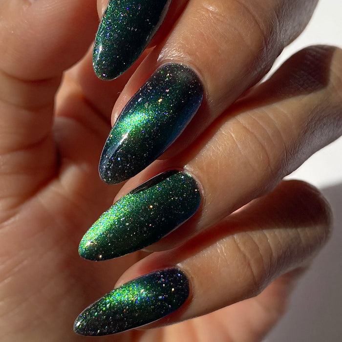 Close-up of nails painted with Planetary Attraction Nail Lacquer on medium skin tone, on a beige background.