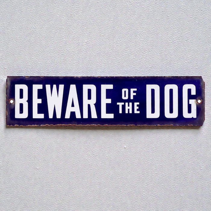 metal sign with 'Beware of the Dog' text on a gray background