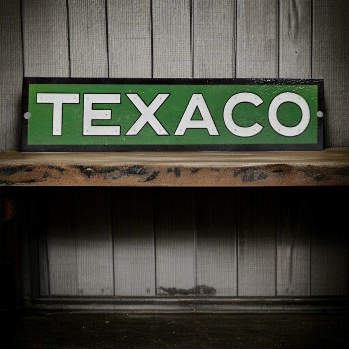 Vintage Texaco sign on a wooden shelf with a wooden paneled background