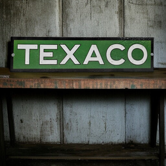 Vintage Texaco sign on a wooden surface with a rustic background