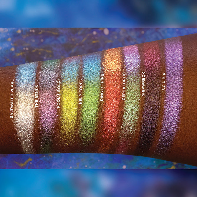Arm swatches on deep skin tone of all eight eyeshadows included in the Deep Sea Treasures Palette.