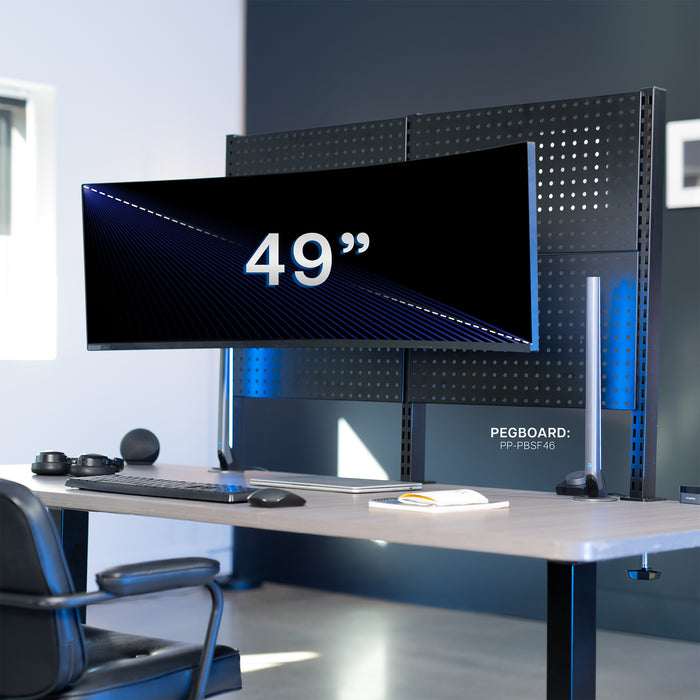 Large computer monitor mounted on a  pegboard on desk in modern office space.