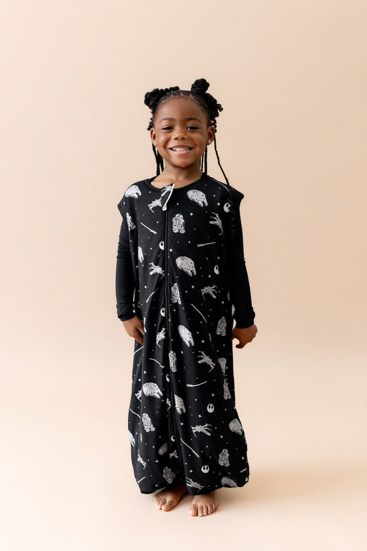 Smiling girl wearing the Sleep Bag Walker in STAR WARS™ 1.0 with long sleeve black pajamas on underneath