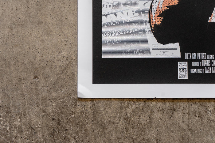 A close-up of a slightly damaged 18x24 Bane poster’s corner on rough gray concrete. The poster displays text, graphics, and a stylized orange and black image with visible film credits and logo. No refunds.