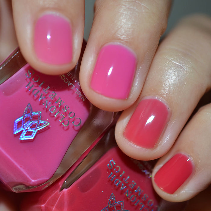Close-up of nails painted with Stratus Nail Lacquer on fair skin tone. Hand is holding polish bottle.