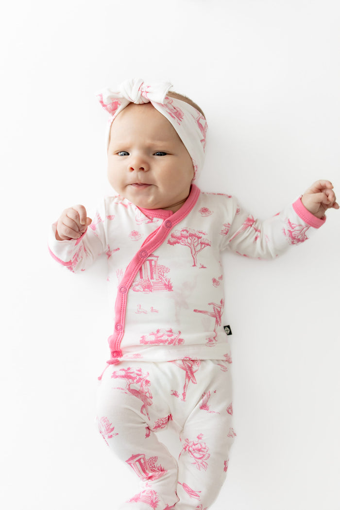Close up of newborn laying on a white surface wearing the Take Me Home Set with Bow in Toile Ballet