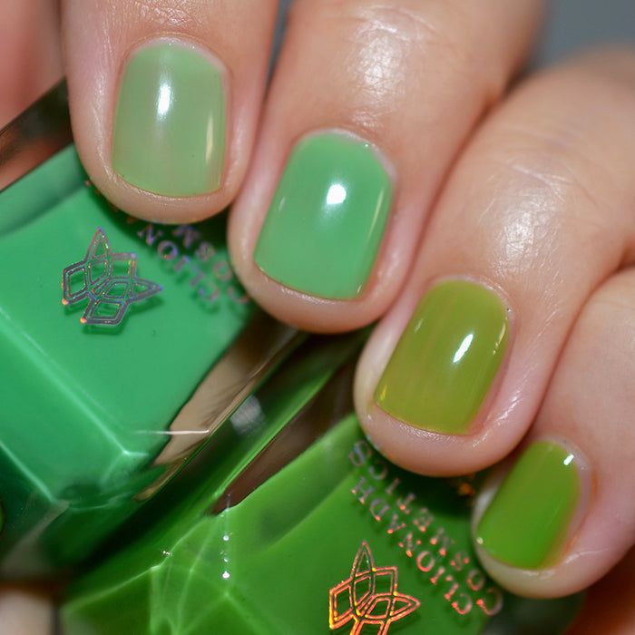 Close-up of nails painted with Thrilled Nail Lacquer on fair skin tone. Hand is holding polish bottle.