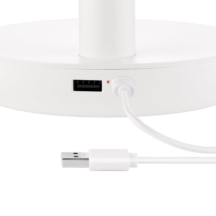 Nahaufnahme des Unold TISCHVENTILATOR BREEZY, einem weißen elektronischen Gerät mit USB-Anschluss und Stromeingang. Ein weißes USB-Kabel ist eingesteckt, am anderen Ende ist eine kleine rote Kontrollleuchte sichtbar.