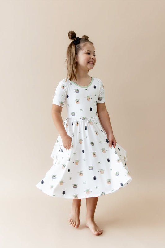 Young girl twirling wearing the Twirl Dress in Grogu™