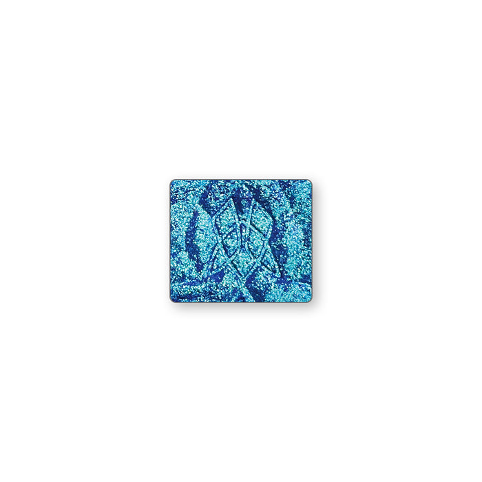 A single multichrome eyeshadow in colour Verre on a white background. An indigo base with a green to aqua to violet shift