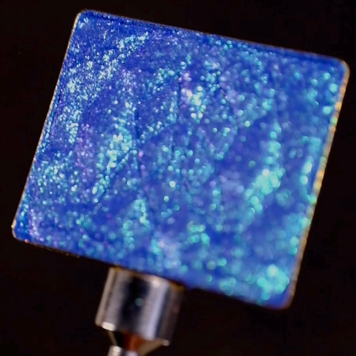 Close-up of Verre eyeshadow in a single pan, on a black background.