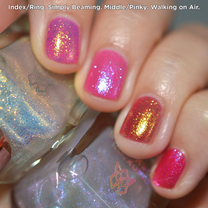 Close-up of nails painted with Walking on Air Nail Lacquer on fair skin tone. Hand is holding polish bottle.
