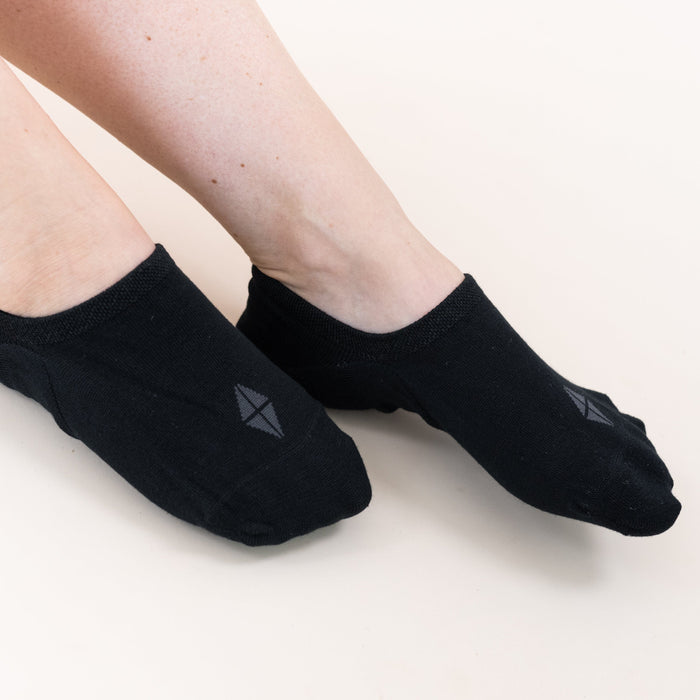 Model wearing a Pair of Kyte Baby Bamboo Women's No Show Socks in Midnight Black
