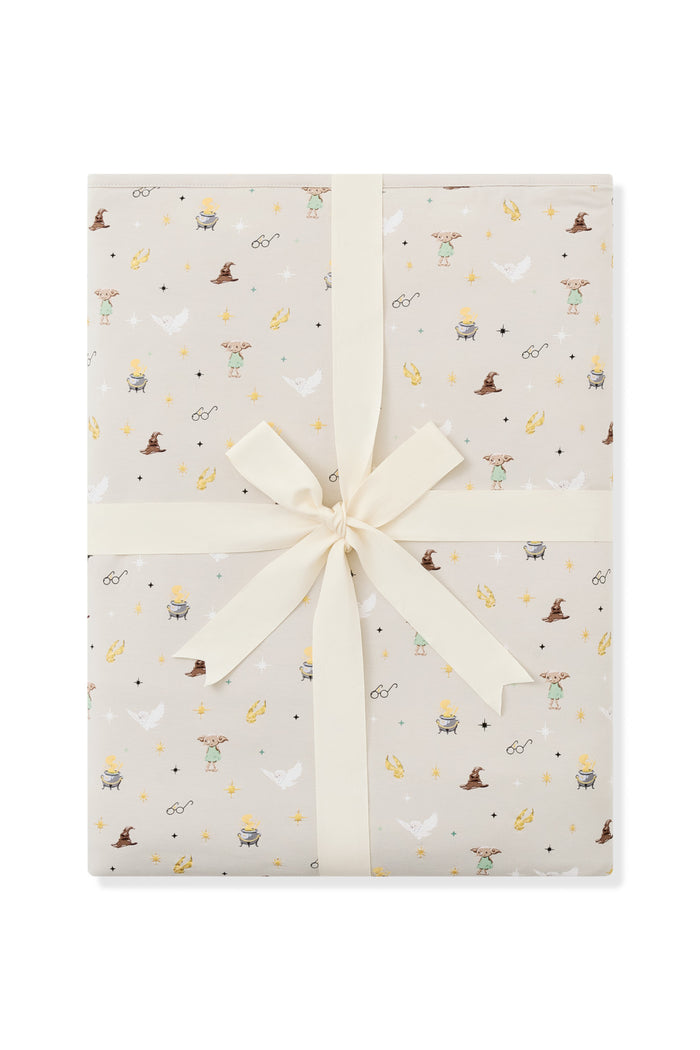 Packed Beige Youth Blanket in Harry Potter pattern print with a ribbon on a white background